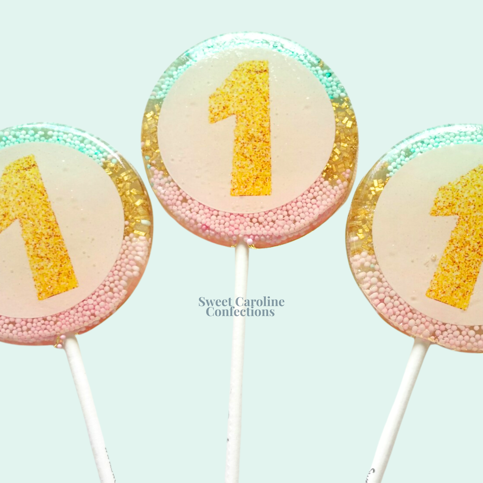 00365 EDIBLE WITH OMBRE AQUA, GOLD AND LIGHT PINK IN THE BACK - Sweet Caroline Confections | The Original Sparkle Lollipops