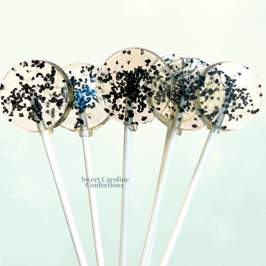 Sleek, clear lollipops showcasing black Hawaiian sea salt. 