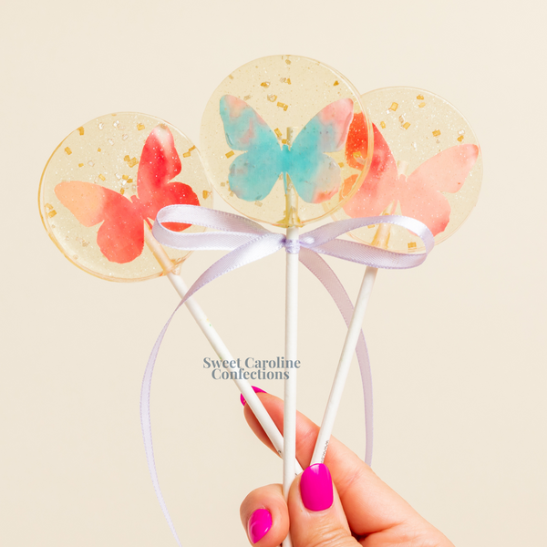 Assorted colorful butterfly lollipops with vibrant edible sparkles.