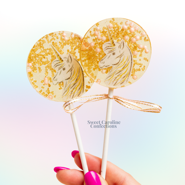 Gold and light pink mystical pony lollipops, hand-cut and hand-painted hard candy with sparkling accents from Sweet Caroline Confections.

