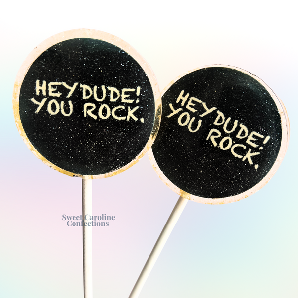 Sparkly round lollipops with "Hey Dude You Rock" text and edgy edible designs.