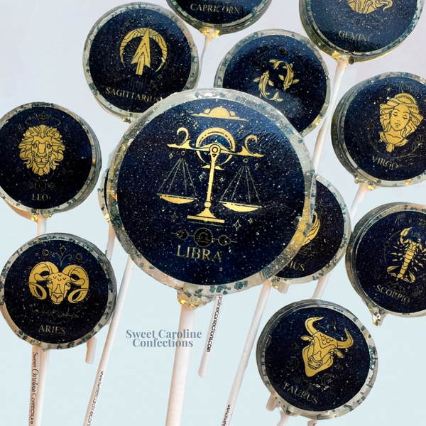 Navy and gold zodiac-themed horoscope lollipops with raspberry flavor.