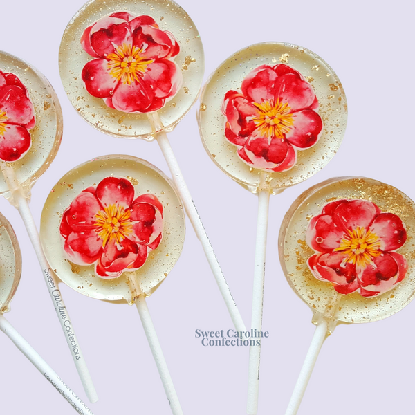 Bold hot pink flower lollipops with vibrant edible petals and signature gold glitter.