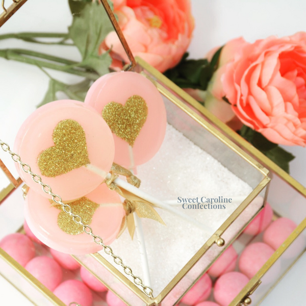 Light pink lollipops with a gold heart and sparkle