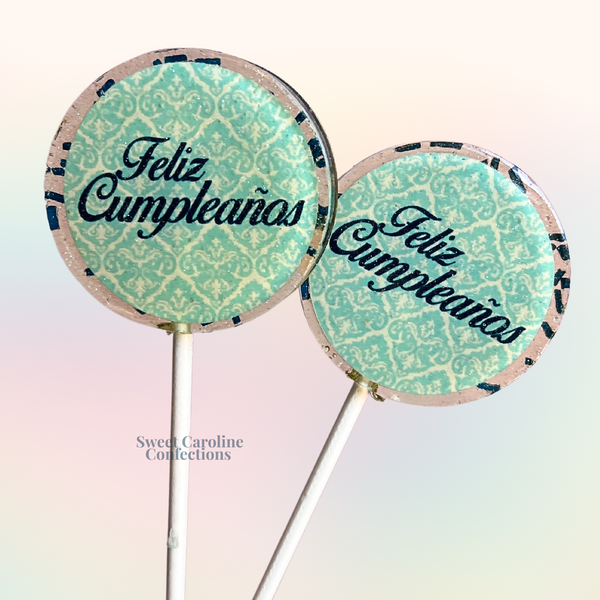 Navy and aqua lollipops with "Feliz Cumpleaños" text and sparkling accents, perfect for a Spanish-themed birthday.
