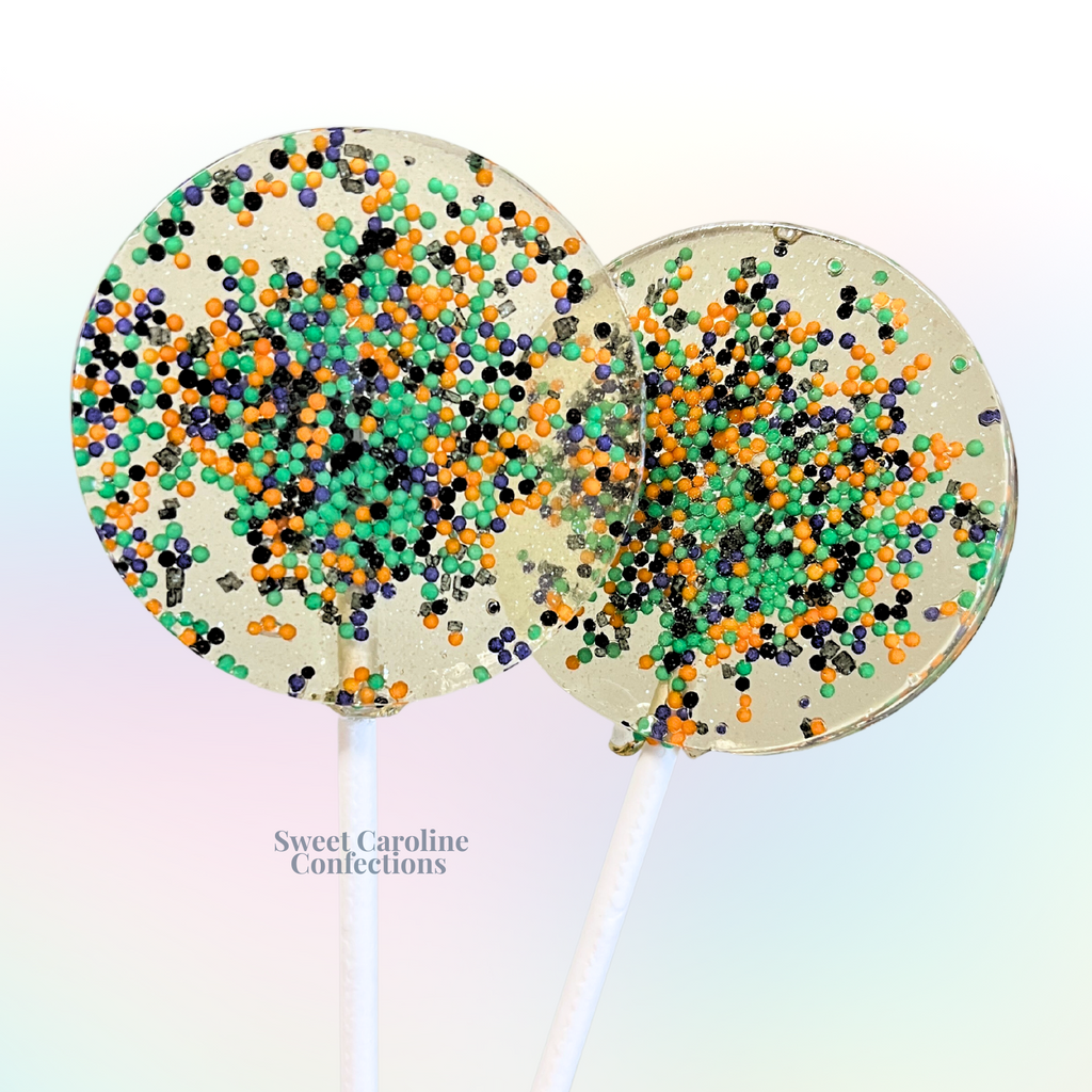 Orange, green, purple, and black Halloween sparkle lollipops filled with colorful sugar crystals from Sweet Caroline Confections.

