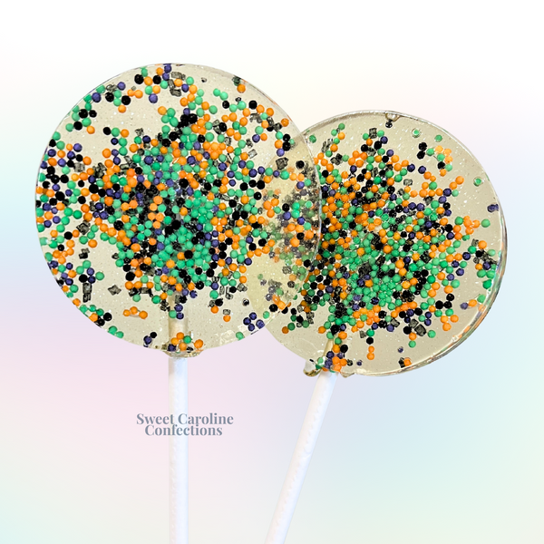 Orange, green, purple, and black Halloween sparkle lollipops filled with colorful sugar crystals from Sweet Caroline Confections.

