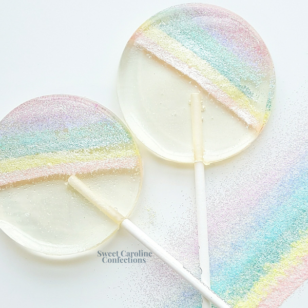 Pastel rainbow sparkle lollipops with a detailed hand-designed pastel rainbow in signature clear sparkle candy from Sweet Caroline Confections.

