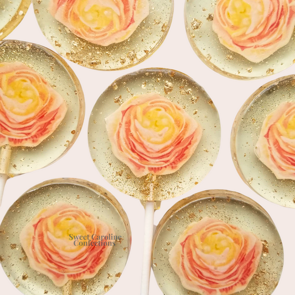 Soft peach ranunculus flower lollipops with layered edible petals and gold sparkle details.