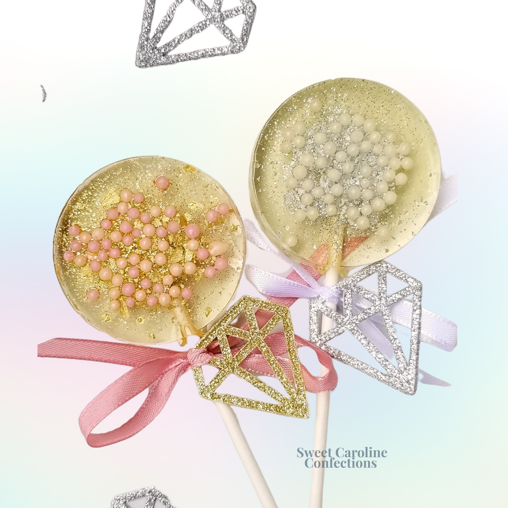 Diamond ring shaped wedding lollipops with pink, gold, and silver accents.