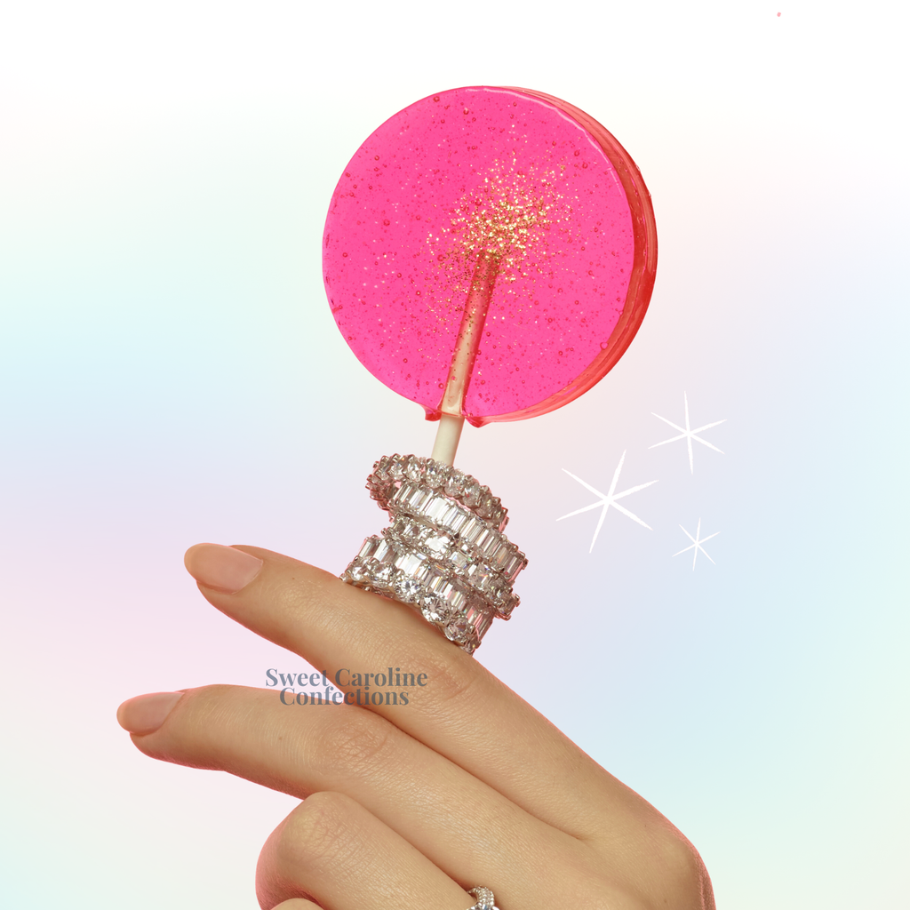 Pink and gold sparkle lollipops with watermelon flavor and edible glitter.