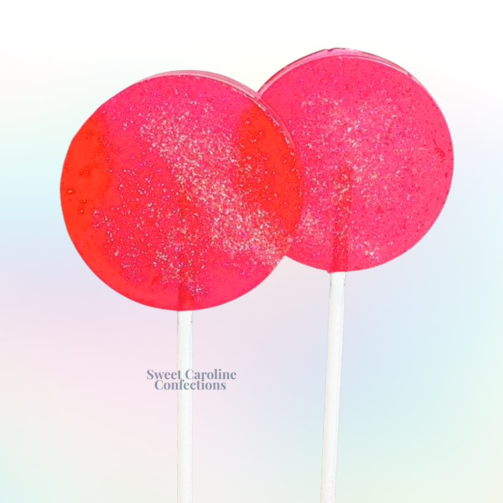 Translucent pink guava flavored sparkle lollipops with gold glitter and tropical-themed sparkles.