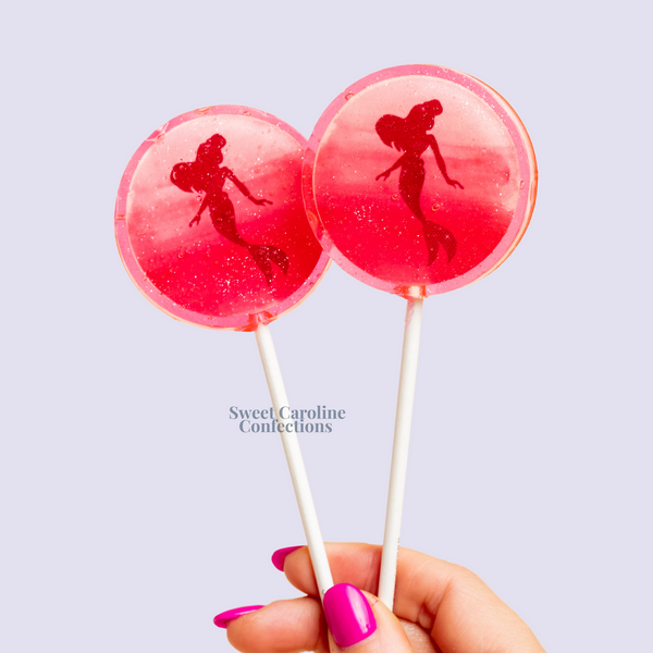 Pink mermaid silhouette lollipop with shimmering edible glitter and a raspberry flavor.