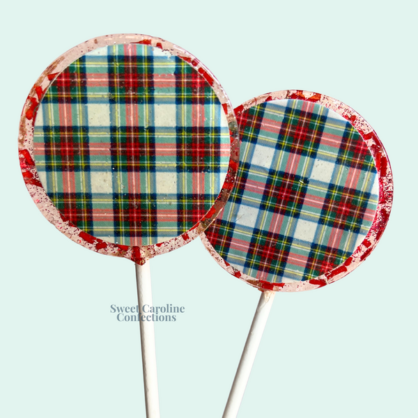 Handcrafted lollipops with vibrant red and green plaid patterns and edible gold leaf.