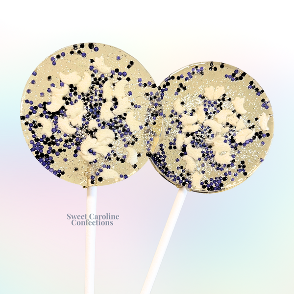Purple and white tiny ghost Halloween lollipops with white ghosts, black sugar crystals, and purple edible glitter from Sweet Caroline Confections.