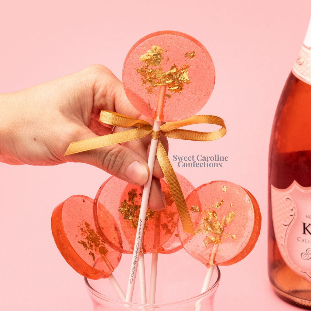 Rosé wine flavored wedding lollipops with edible gold leaf and sparkles.