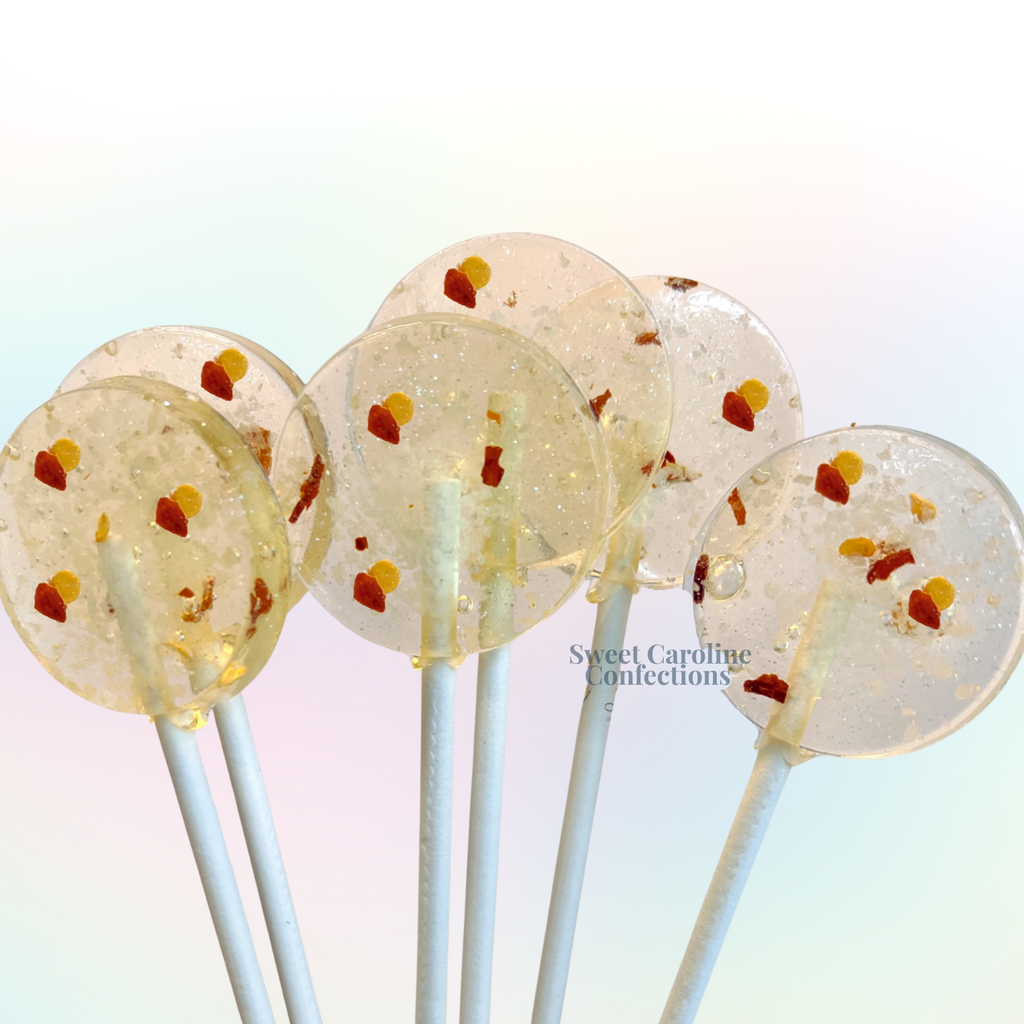 Clear artisanal lollipops with red chili flakes, sea salt crystals, and shimmering edible glitter.