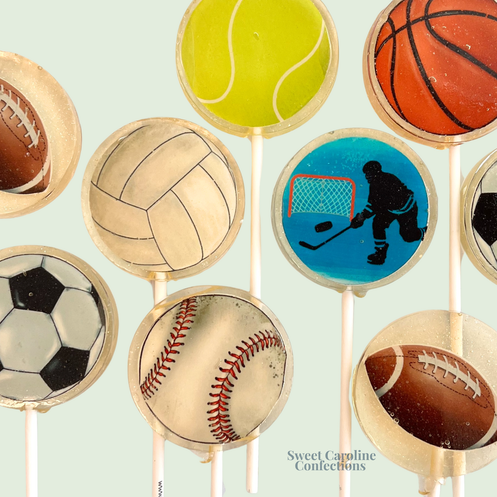Mixed sport-themed lollipops including basketball, baseball, and football designs with gold glitter.
