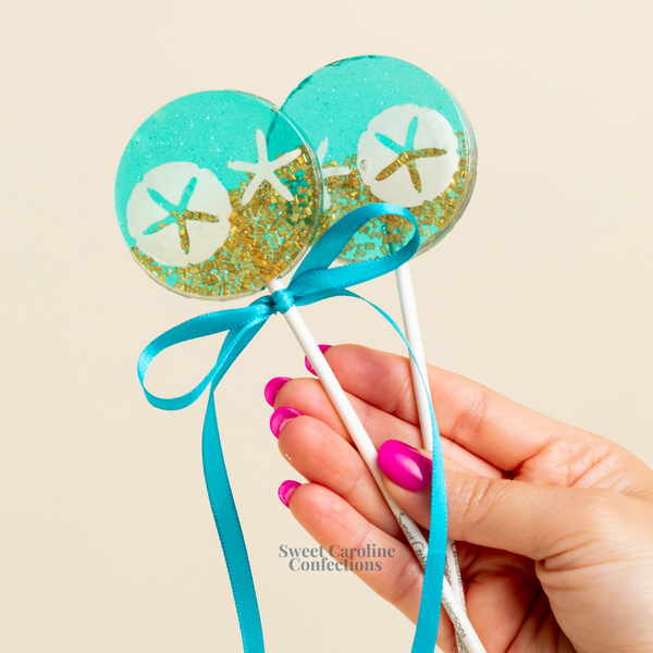 Assorted Under The Sea themed lollipops with shells, fish, and bubbly sparkle designs.