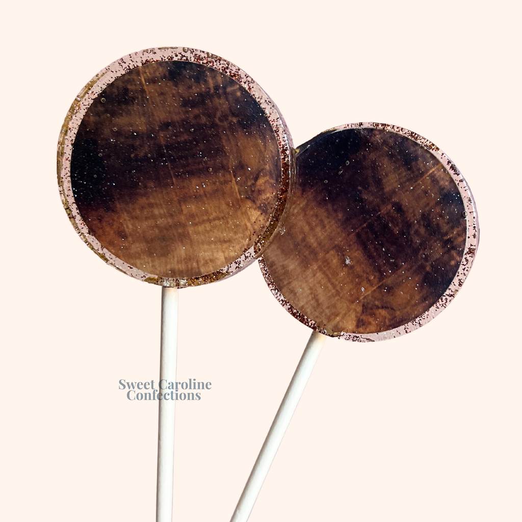 Round lollipops with a realistic brown wood grain edible image and gold glitter.